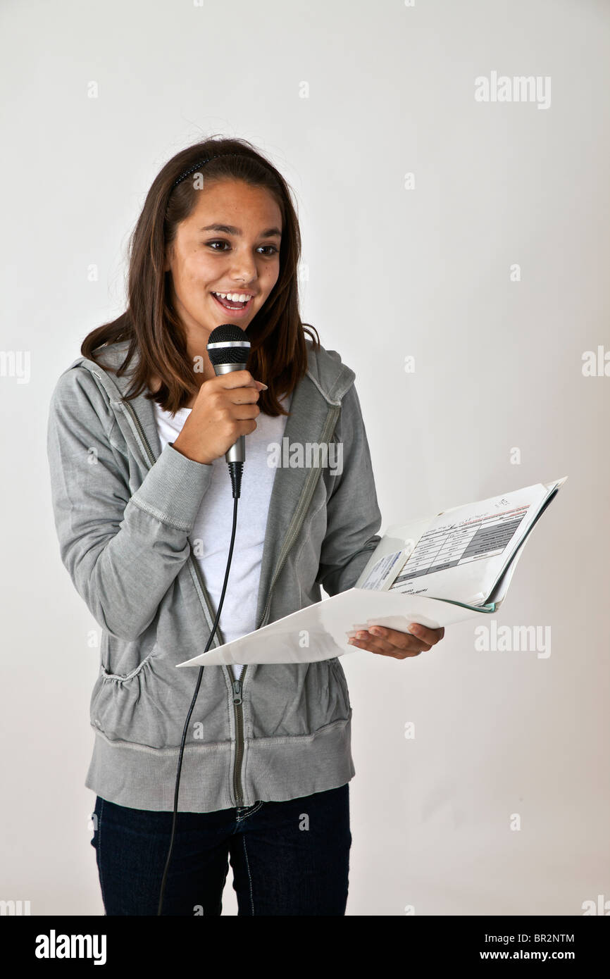Hispanic teen girl holding microphone from of classroom. MR © Myrleen Pearson.  ....Ferguson Cate Stock Photo