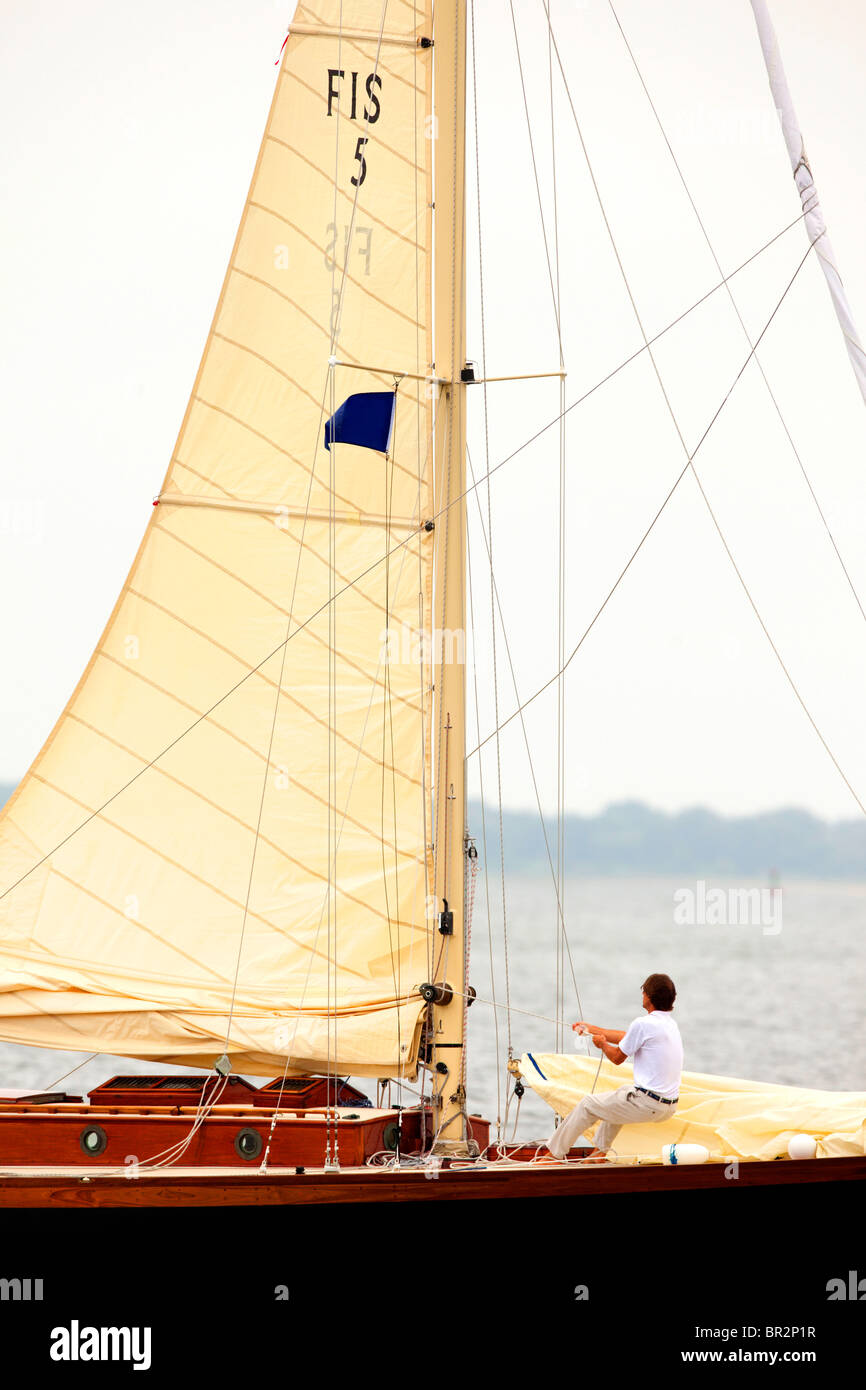 Man pulling sail up on sailboat Stock Photo Alamy