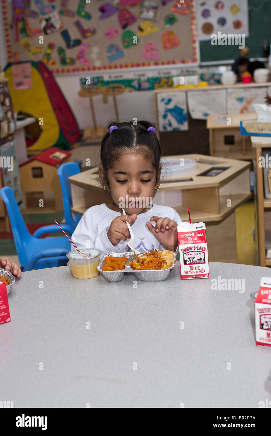 4 year old preschool girl eating lunch in the classroom Stock Photo - Alamy