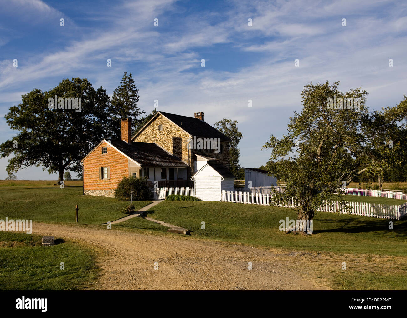 Old brick stone house with white picket fence - Virginia USA Stock Photo