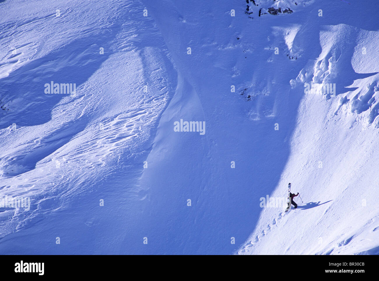 Backcountry snowboarder hiking for turns Stock Photo - Alamy