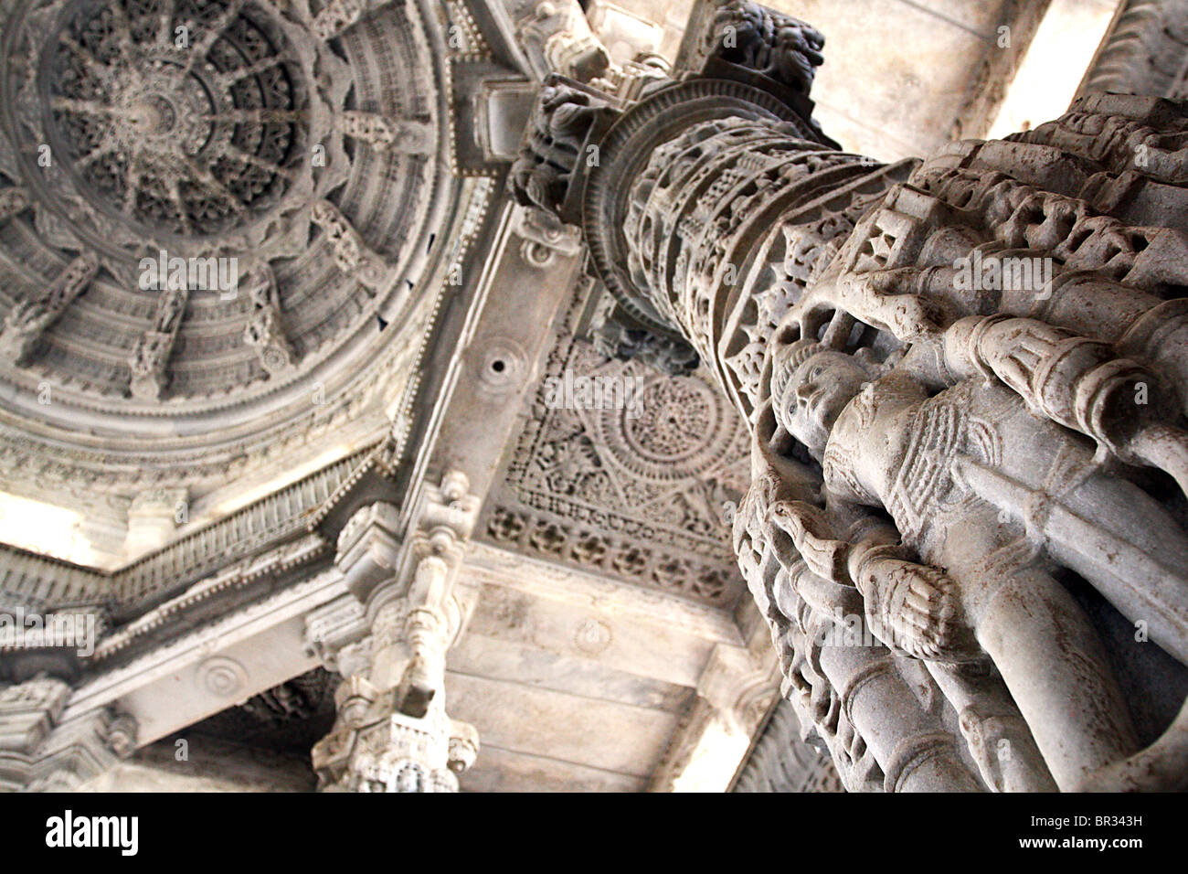 Intricately carve stone mandala ceiling and Jain holy figure in the great Jain temple of Ranakpur in Rajasthan, India. Stock Photo