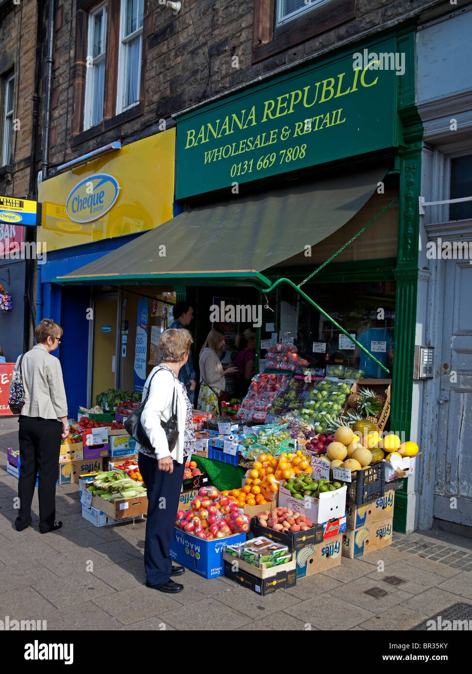 Shoppers looking at produce at grocers shop,Portobello Stock Photo