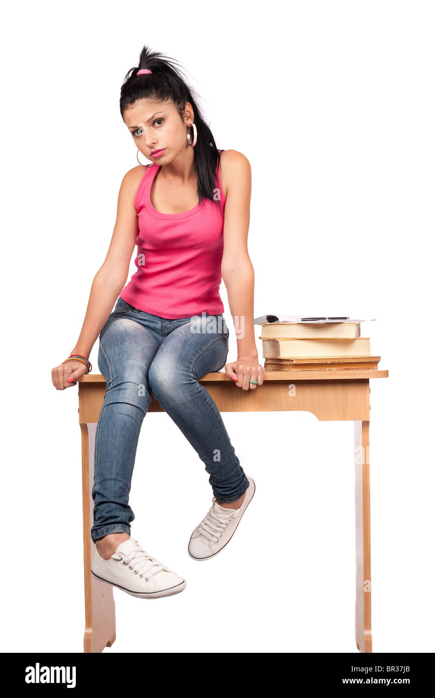 Beautiful student girl sitting on her desk with a stack of