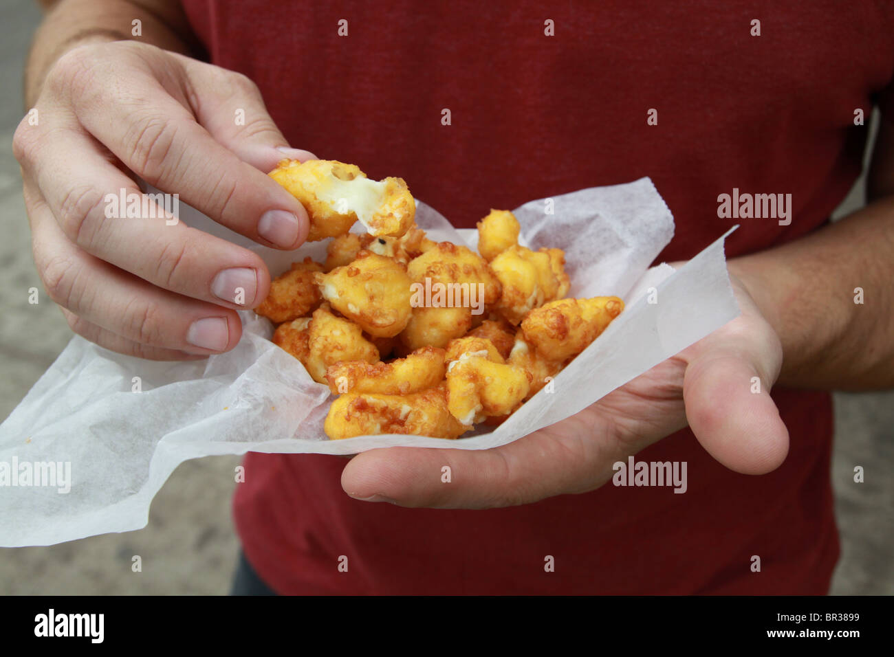 A man holding a serving of cheese curds at the Minnesota State Fair