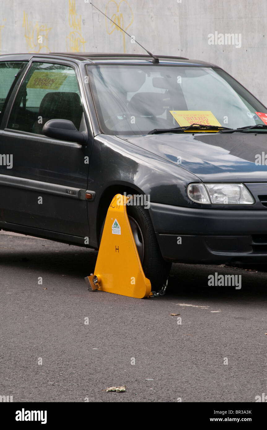 Illegal, untaxed and wheel clamped car in public street Stock Photo Alamy