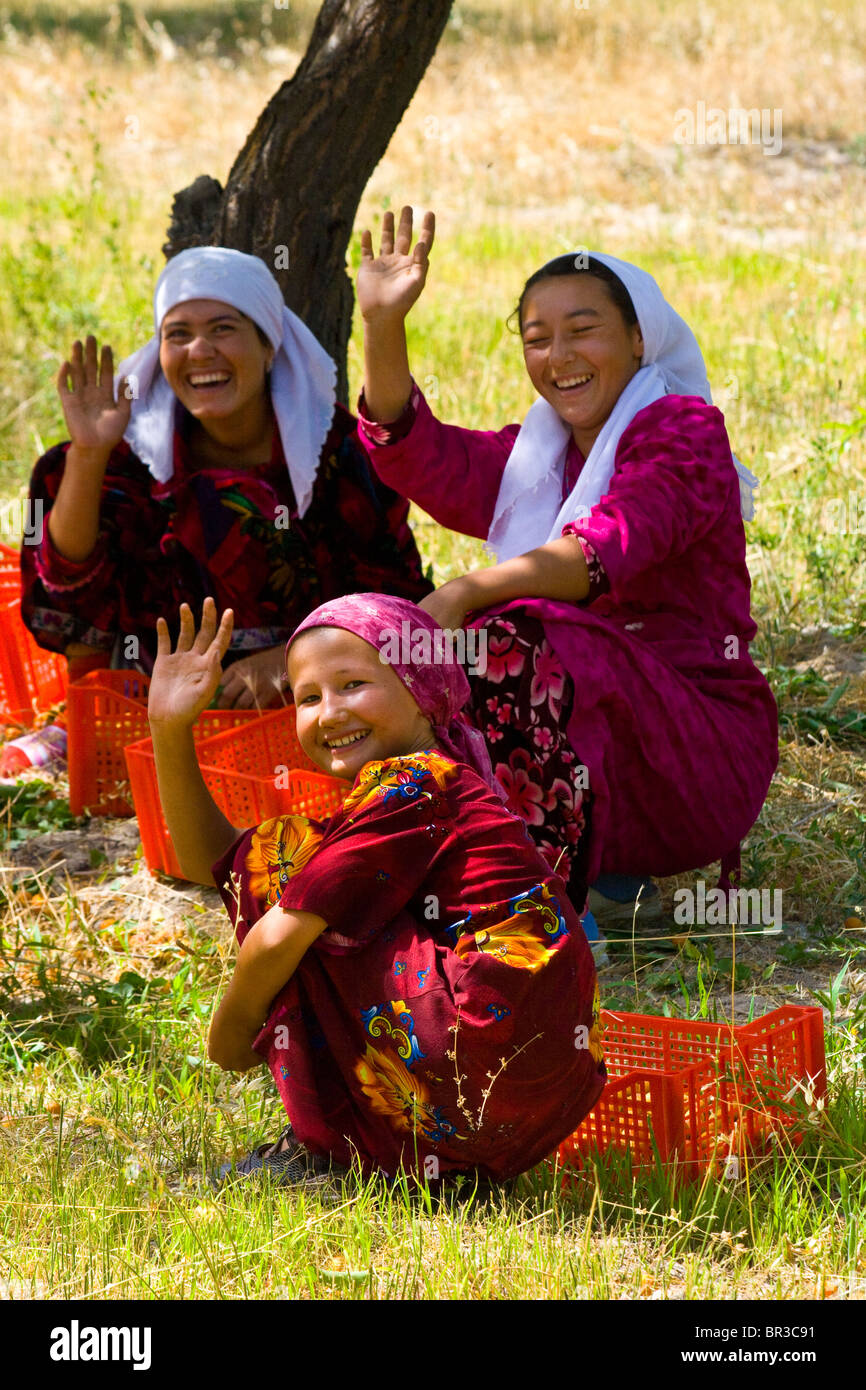 Girls waving in an apricot orchard in rural Uzbekistan Stock Photo