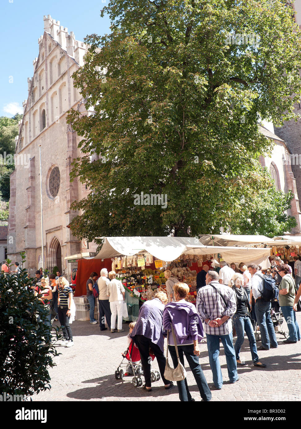 A crowded street market by St Nicholas Cathedral in the historic South Tirol town of Meran or Merano Stock Photo