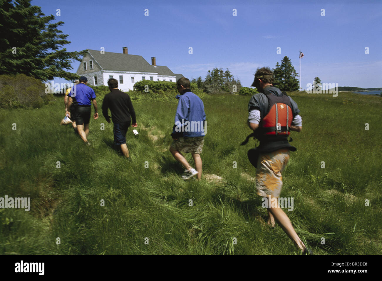 Kayakers cross a field on Harbor Island, Maine in Muscungus Bay. Stock Photo