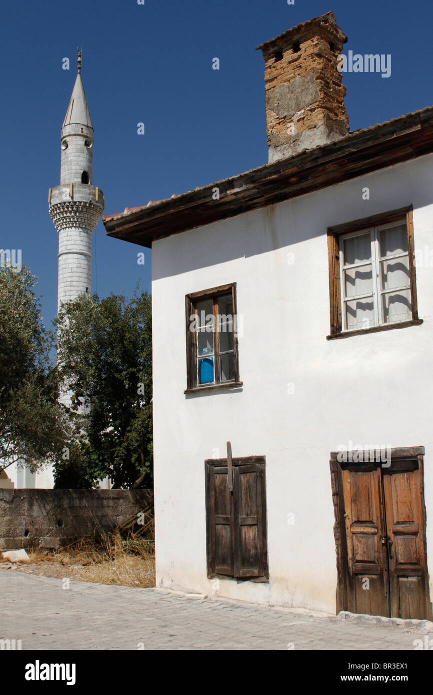 Village house and mosque minaret, Dirgenler, Turkey Stock Photo
