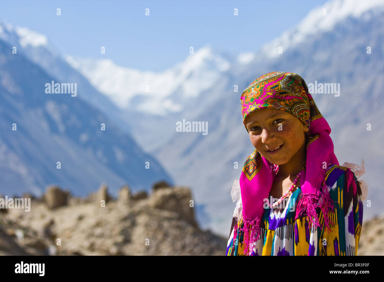 Young Tajik Girl in front of Yamchun Fort in the Wakhan Valley, Badakhshan, Tajikistan Stock Photo