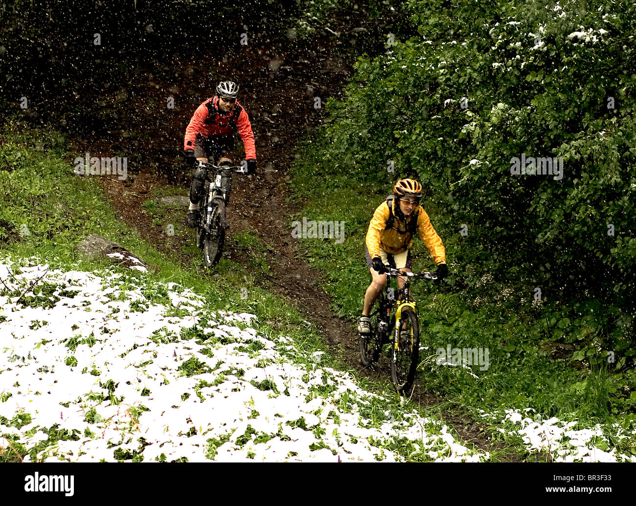 A man and woman mountain biking in the French Alps during the spring in