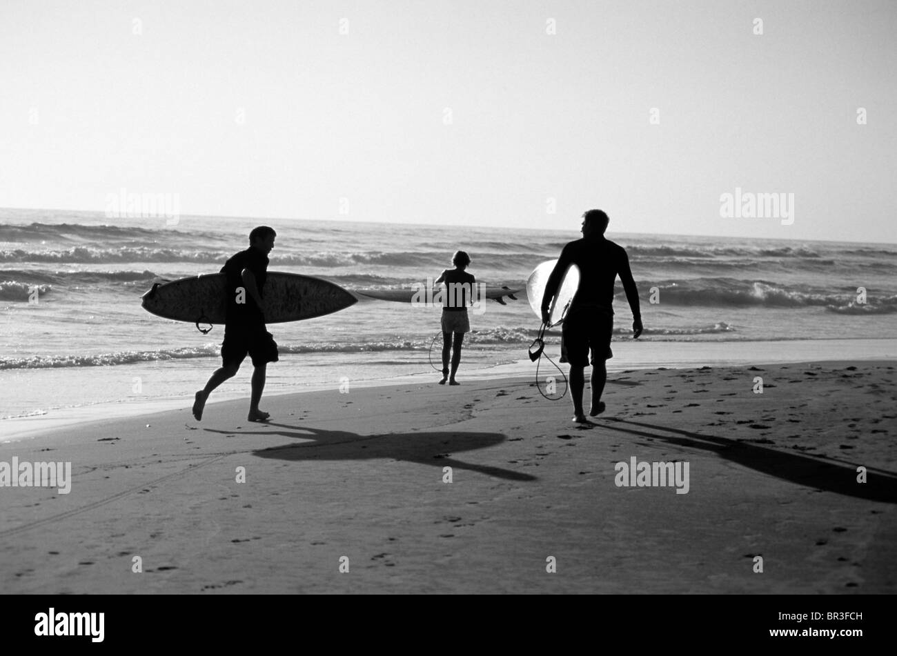Surfers heading out for a session in Troncones, Mexico. Stock Photo