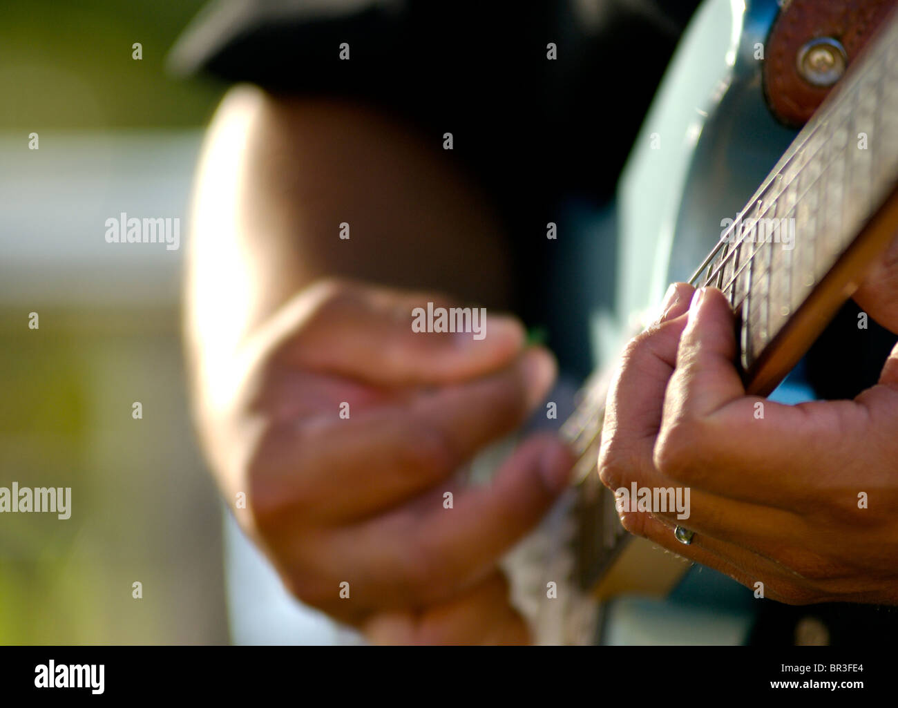 A man plays the guitar at a luau on Maui, Hawaii. (shallow depth of field). Stock Photo