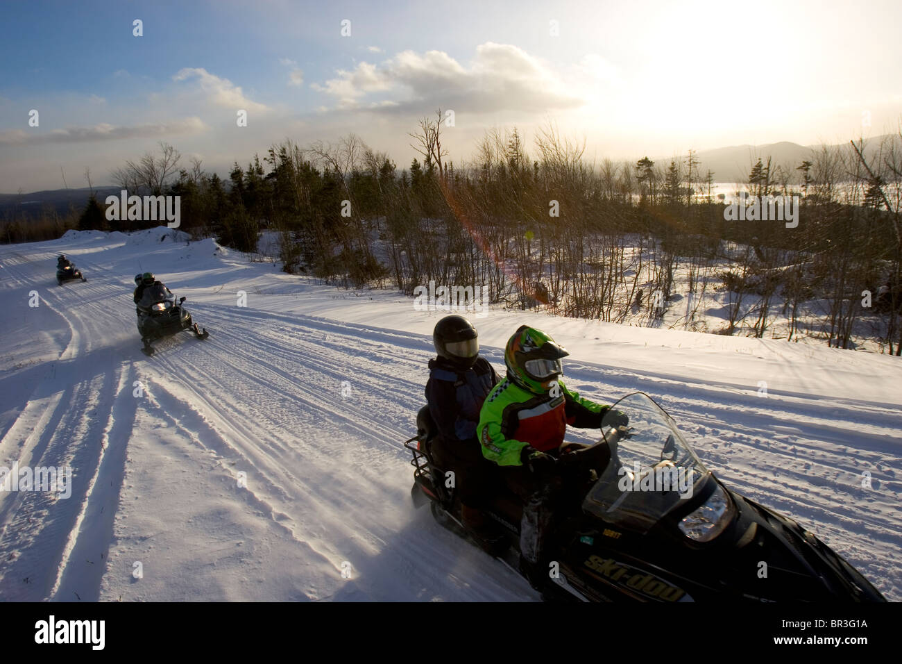 Snowmobilers enjoy a day on a trail in Maine. Stock Photo