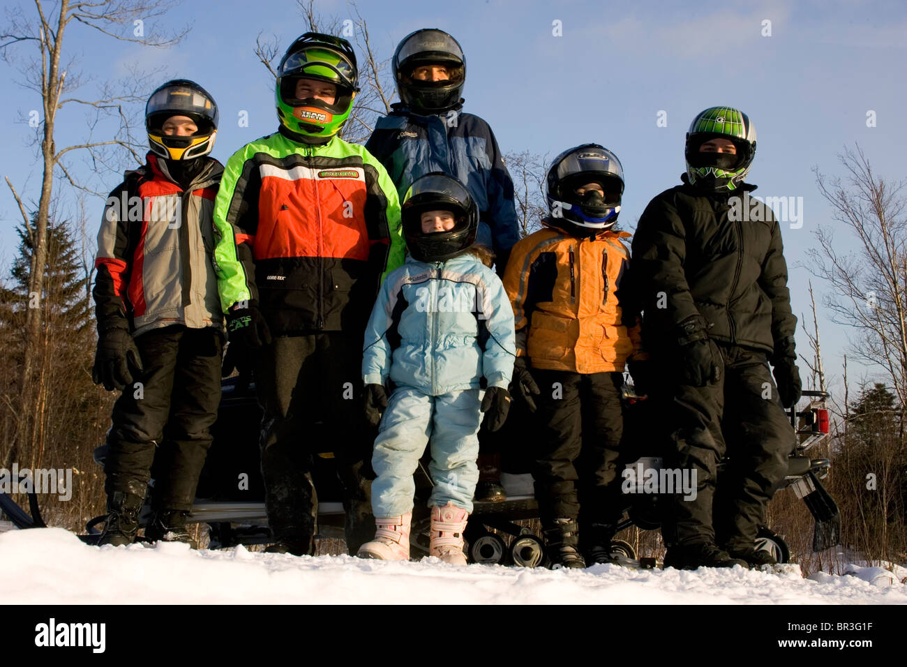 A family poses for a portrait on a snowmobile trail in Maine. Stock Photo