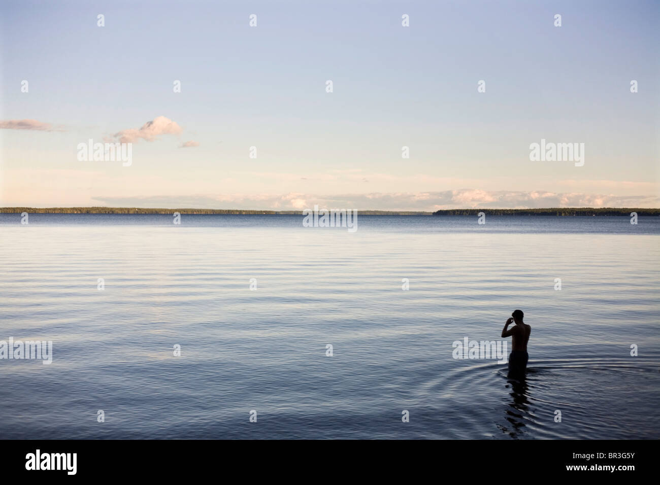 A swimmer prepares to swim at dusk. Stock Photo