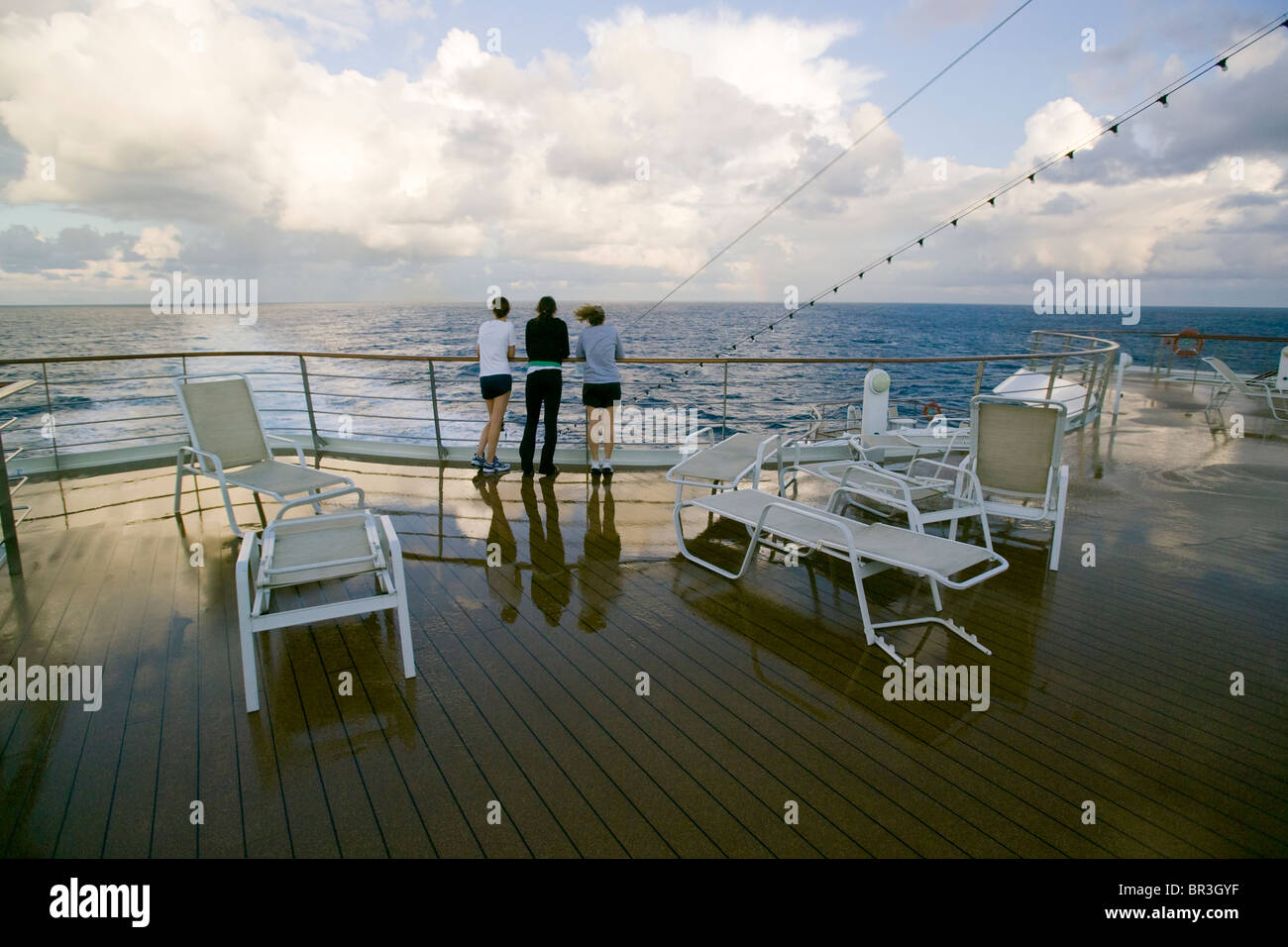 Passengers on the rear deck of a cruise ship on the open ocean Stock