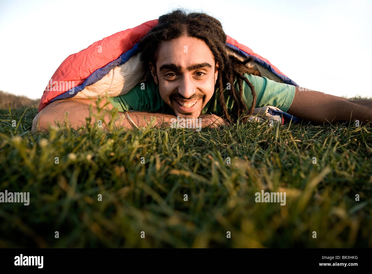 Man inside sleeping bag on the coast of Maine, New England. Stock Photo
