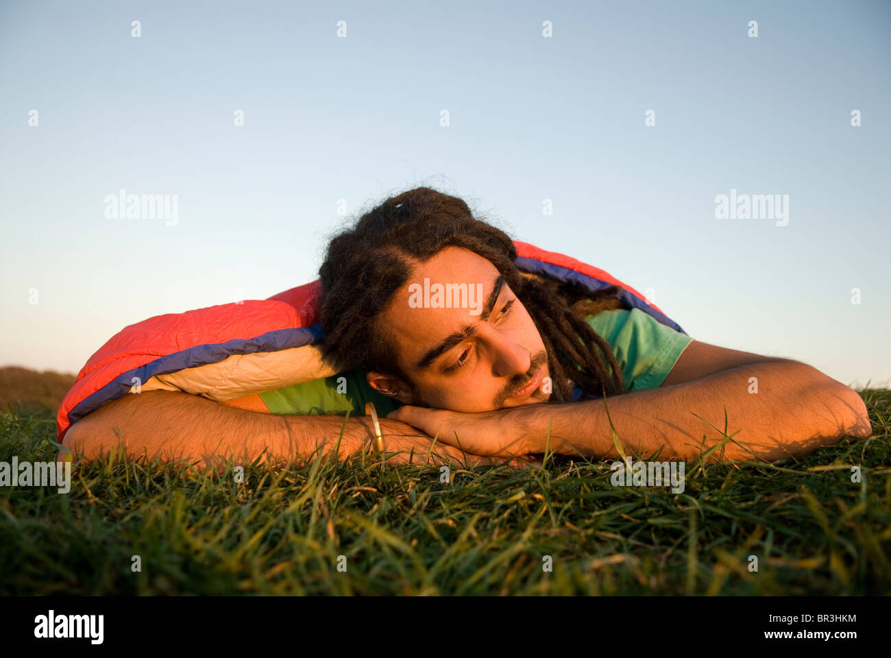 Man inside sleeping bag on the coast of Maine, New England. Stock Photo