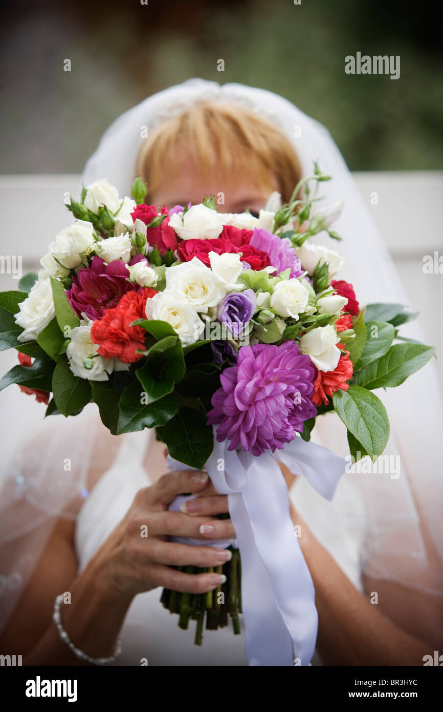 A bride holding her wedding bouquet in front of her face Stock Photo ...