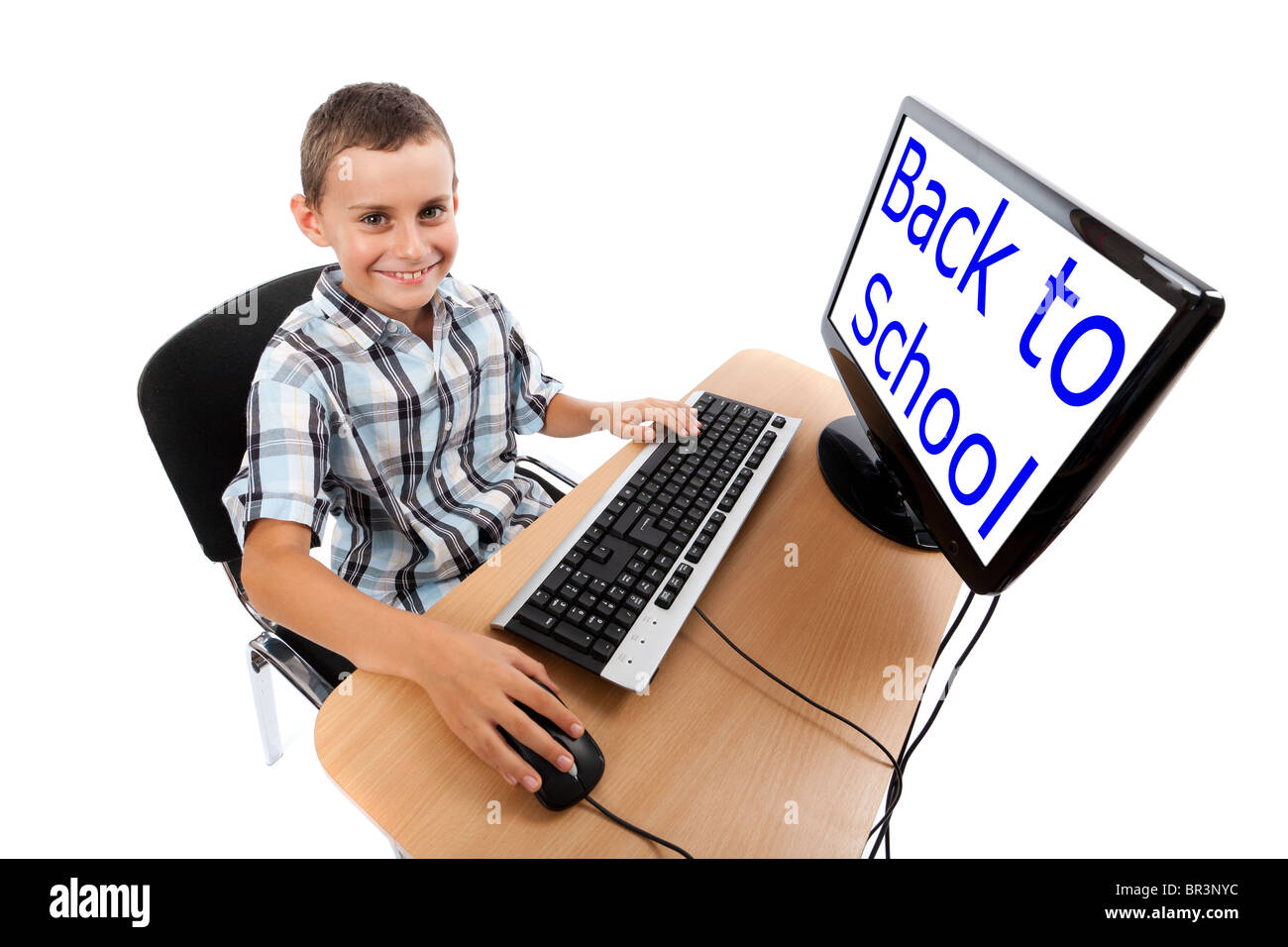 Cute schoolboy at his computer. The monitor can be used as copyspace ...