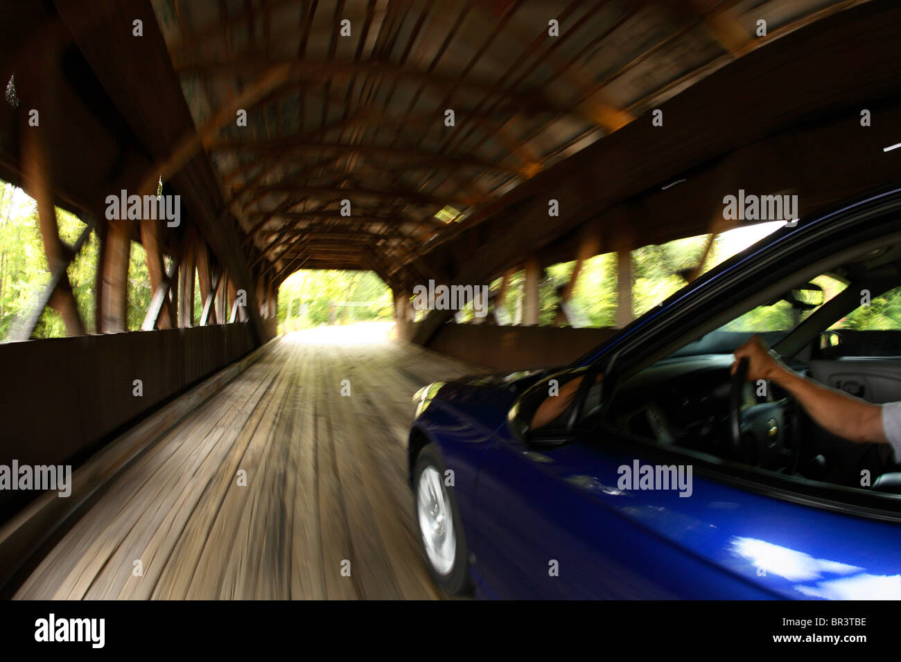 Blur motion photo of a car crossing the Swift River via the Albany covered bridge just off the Kancamagus Highway south of North Stock Photo