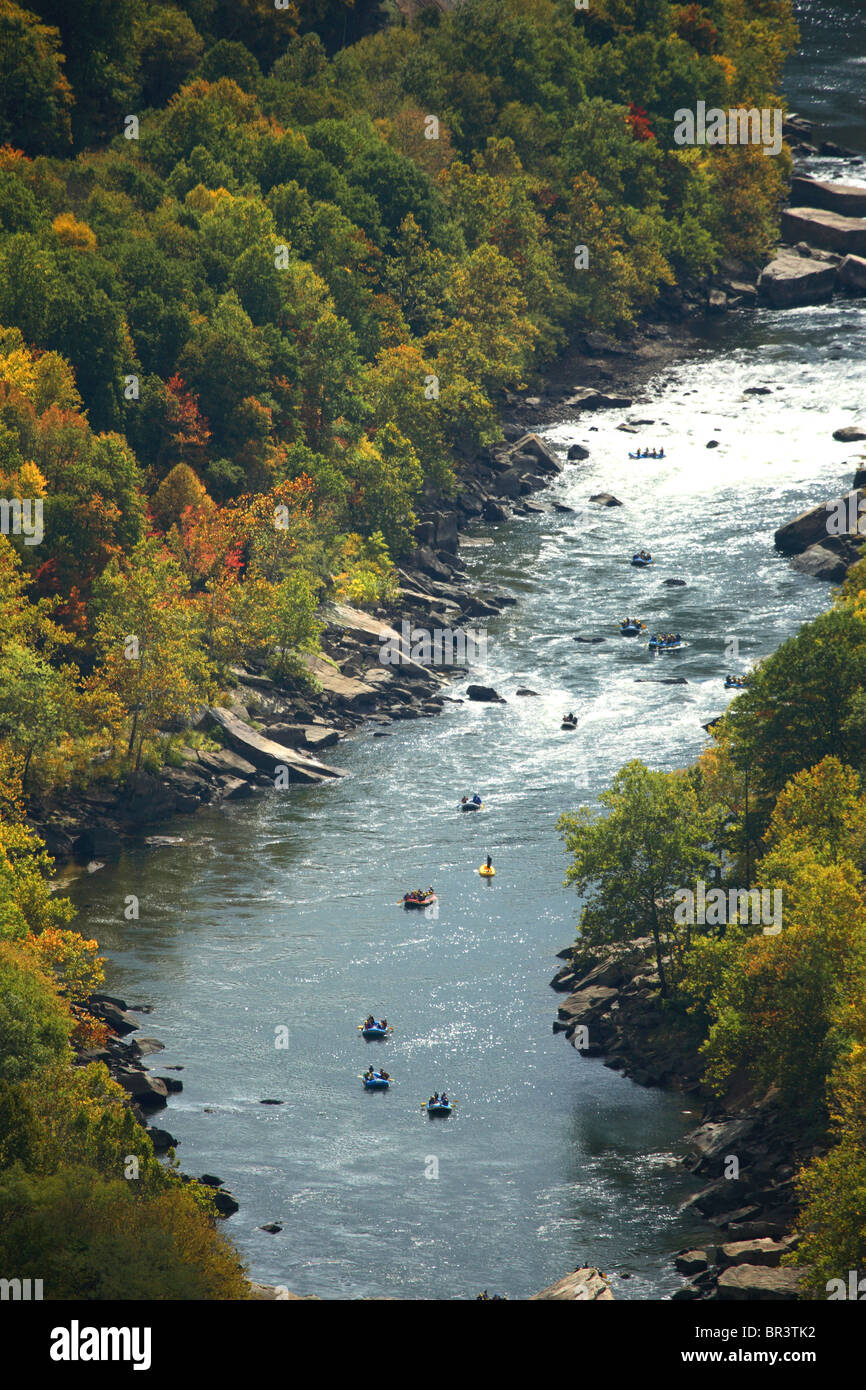 Unknown rafters float down the Lower New River near Fayetteville, WV surrounded by fall colors Stock Photo