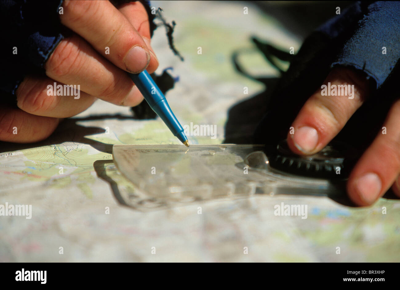 Hands navigating on a map with a compass in an adventure race in ...