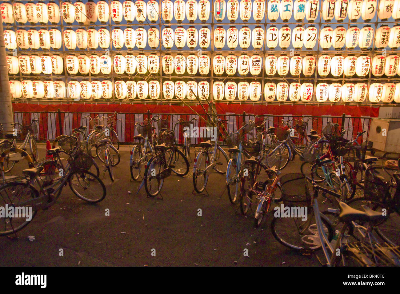 Bikes sit in front of a row of chÅchin lanterns in the streets of Kishiwada city during the Kishiwada Danjiri Matsuri festival, Stock Photo