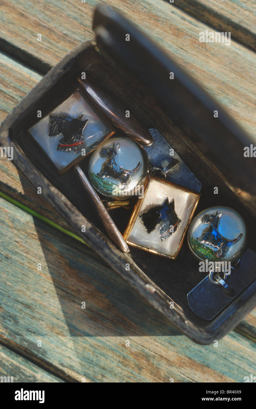 two pairs of Scottie Dog vintage cuff links in a small ebony box on a  wooden slatted surface. close up Stock Photo - Alamy