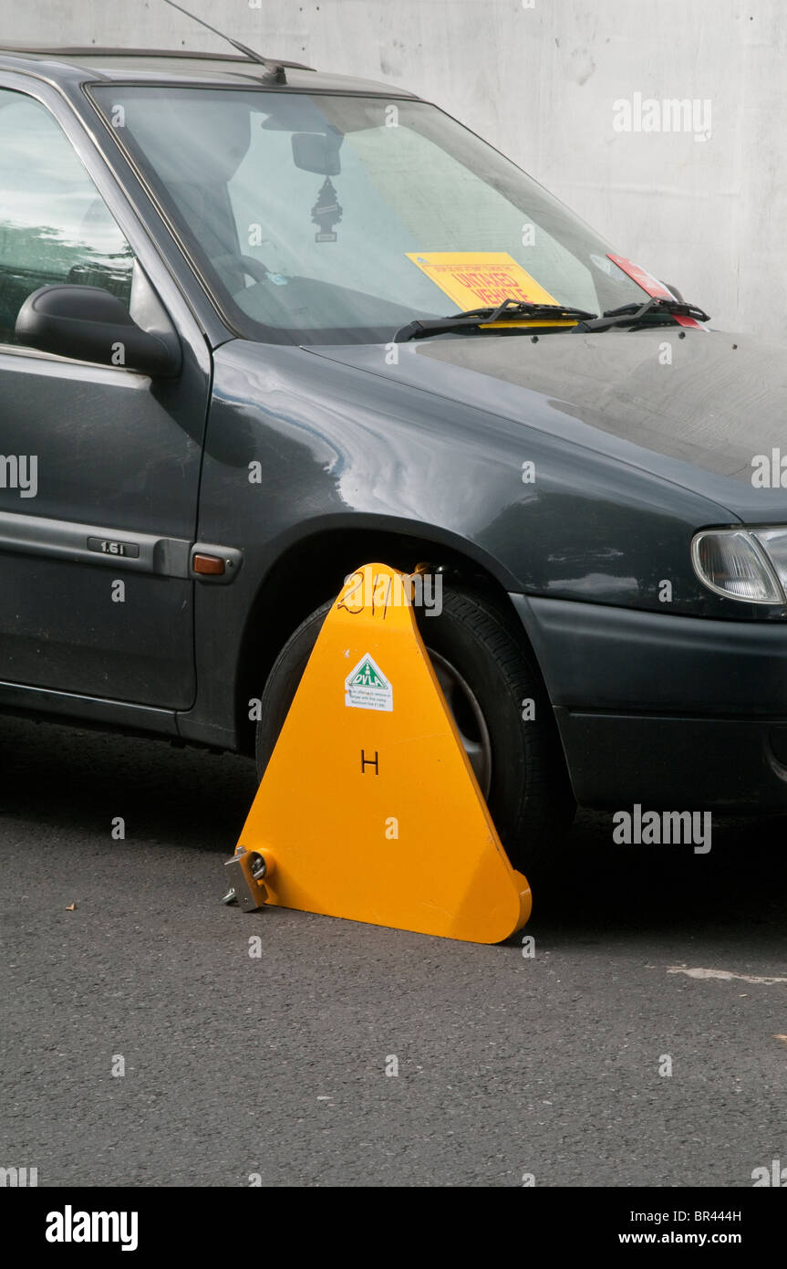 Illegal, untaxed and wheel clamped car in public street Stock Photo Alamy