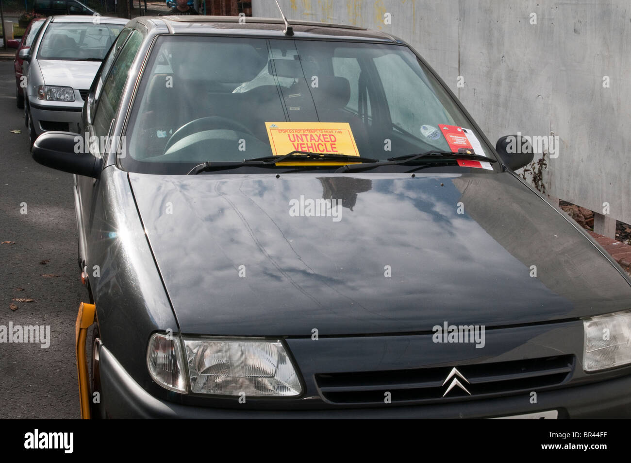Illegal, untaxed and wheel clamped car in public street Stock Photo Alamy