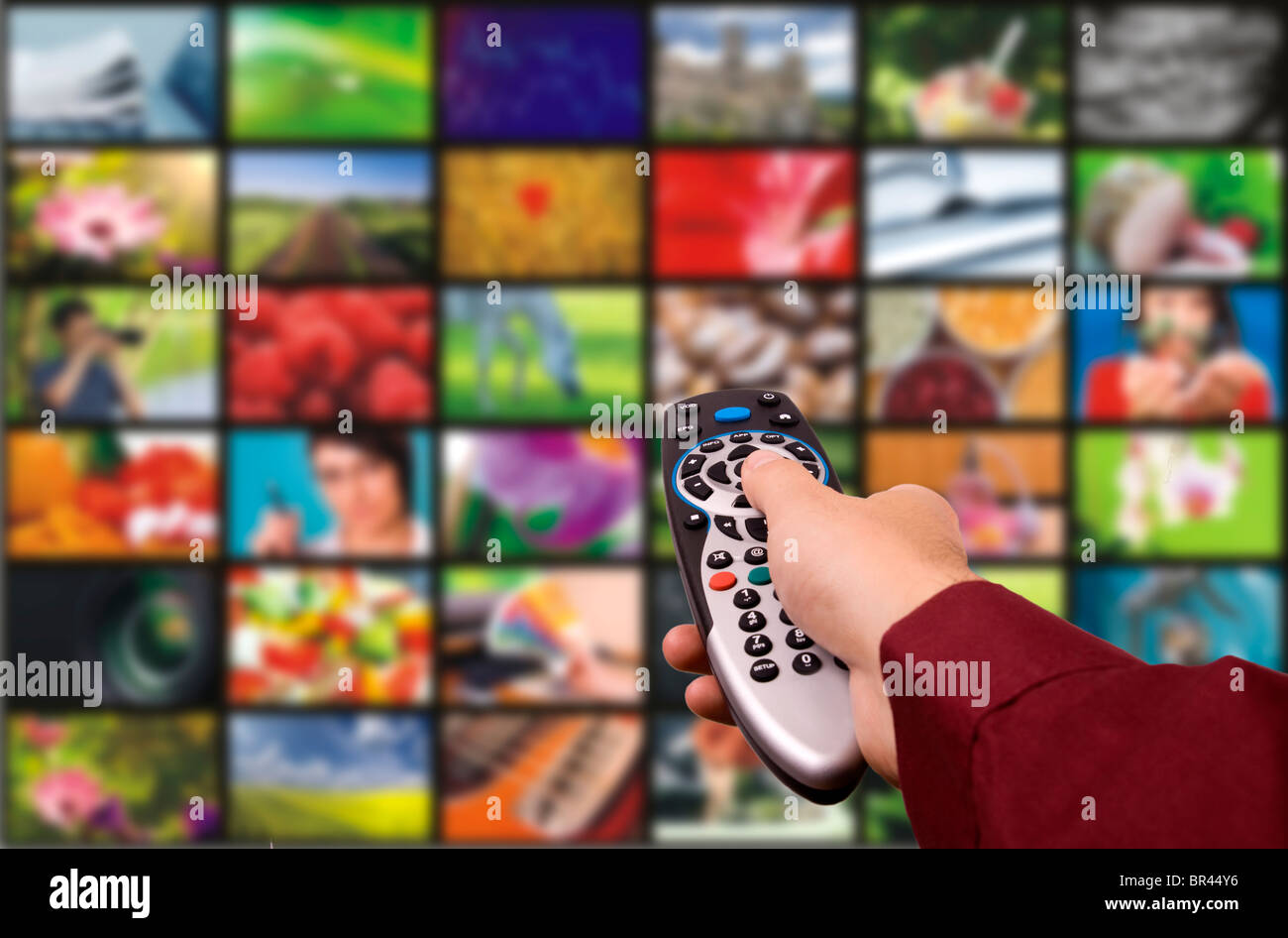 Close up of a hand holding a remote control with a television concept. Stock Photo