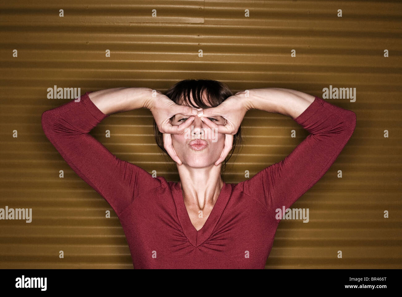 A young woman makes finger glasses and kissing lips in Flagstaff
