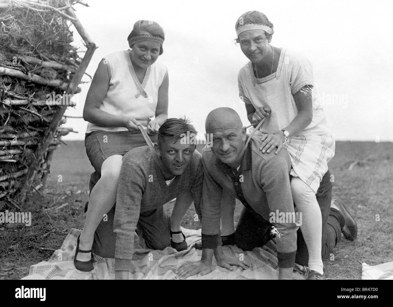 Historical image, two women sitting on two men's backs, ca. 1927 Stock Photo