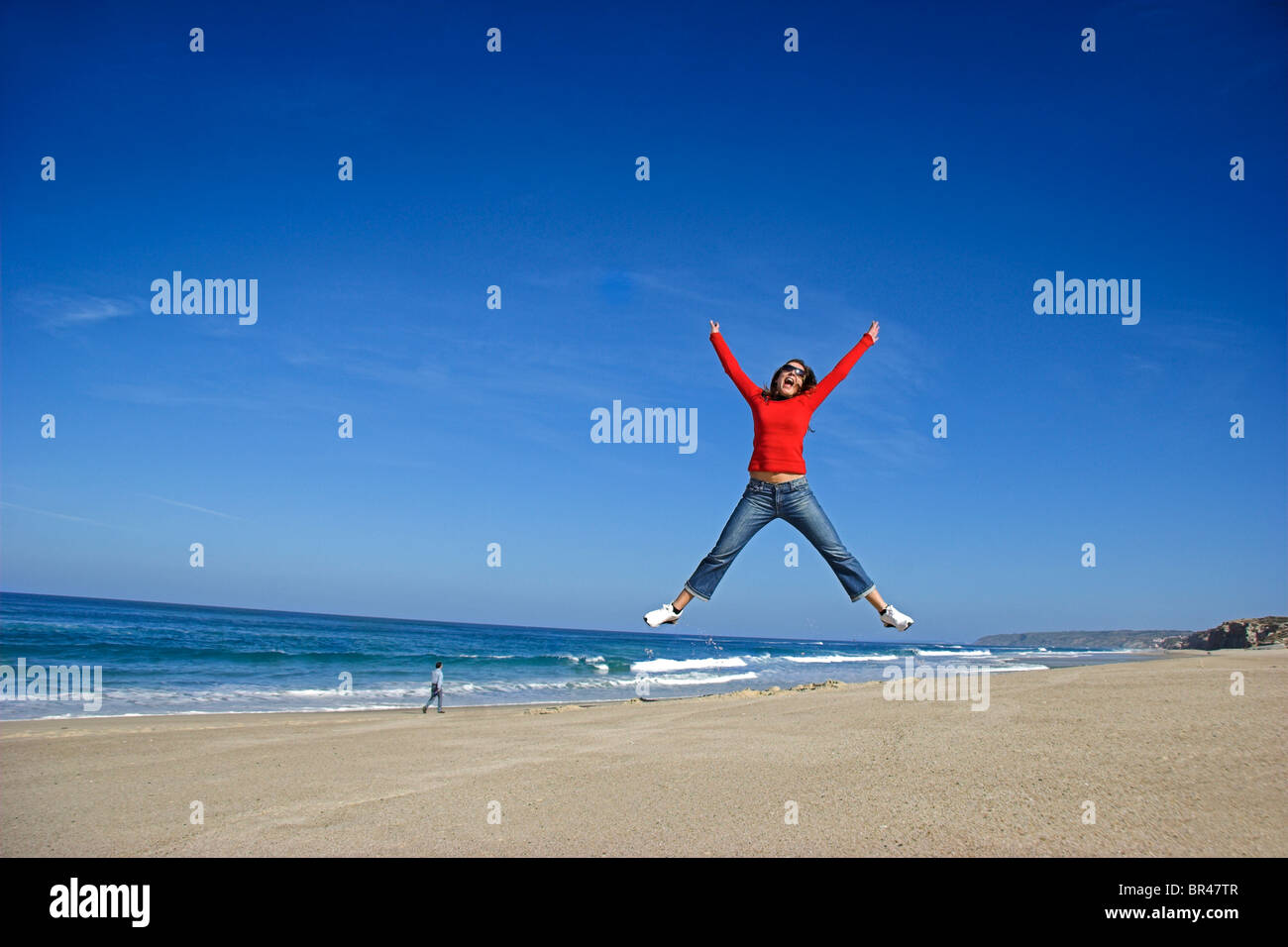 Young woman jumping on the beach and having fun Stock Photo Alamy