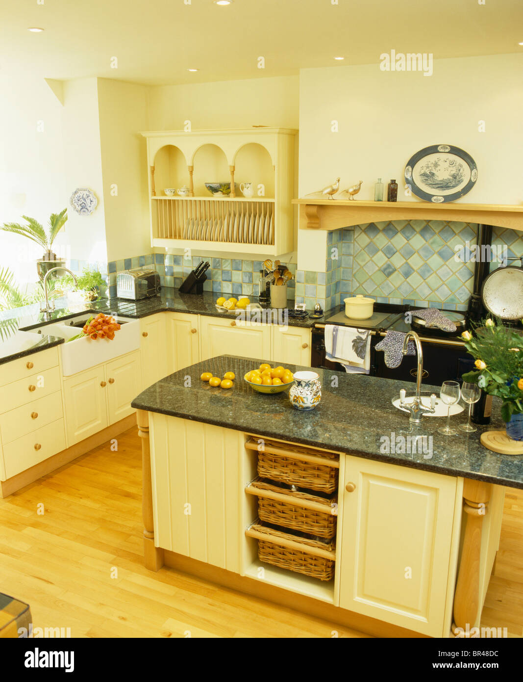 Granite worktop on island unit with storage baskets on shelves in large