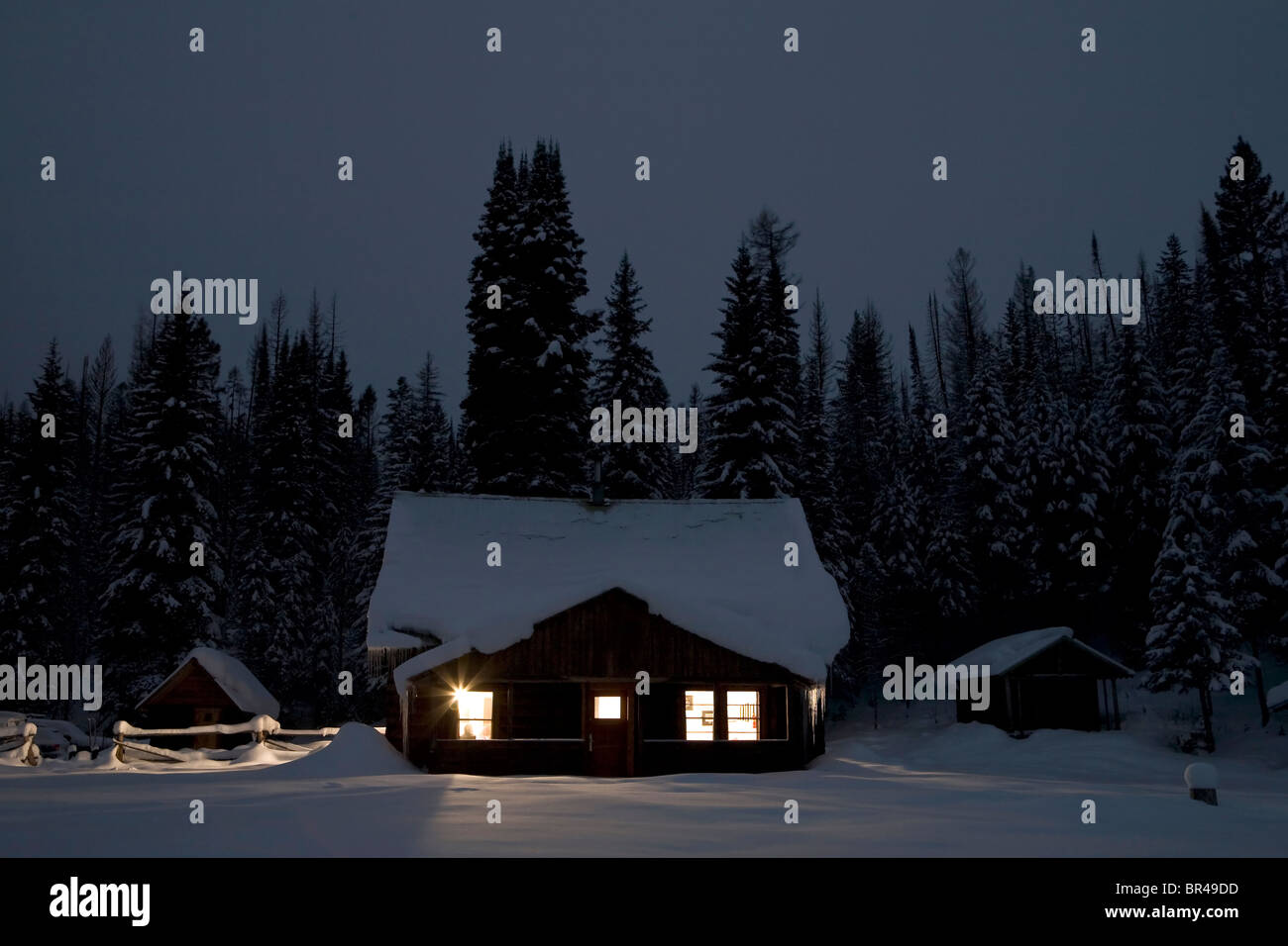 Forest Service Cabin Glowing During Winter Night Polebridge Stock