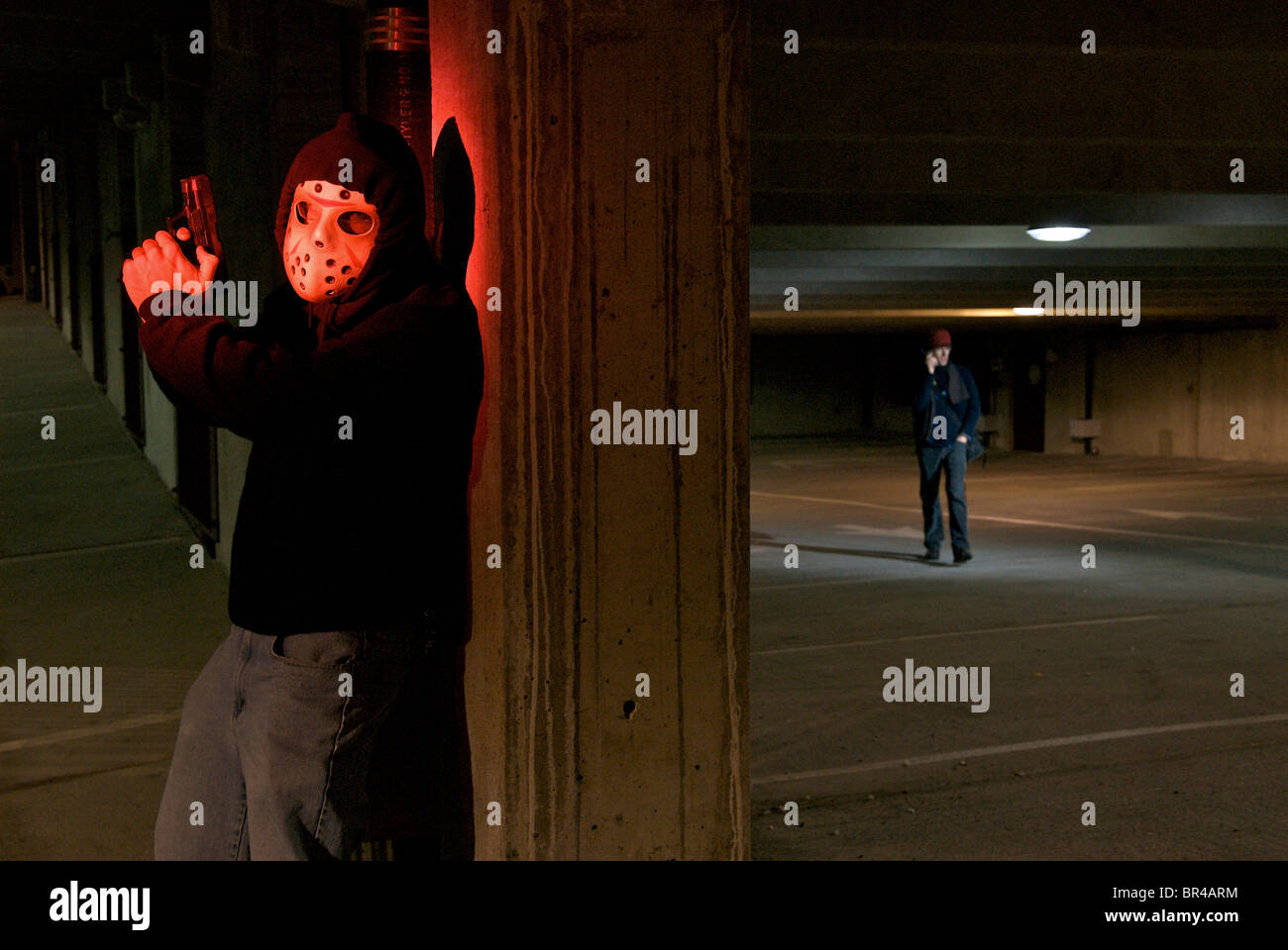 A man being robbed in a parking garage. Stock Photo