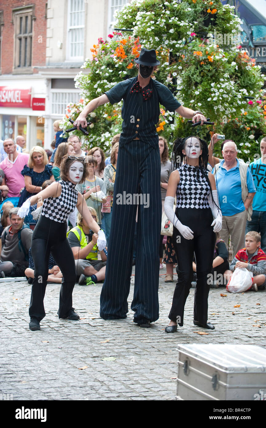 Stilt walker and human puppets at Shrewsbury  International Street Theatre Festival Shropshire, UK Stock Photo