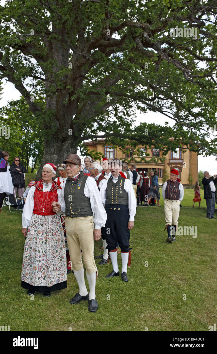 People in traditional Swedish folk costumes at midsummer celebration. Naas castle estate, Sweden. Stock Photo