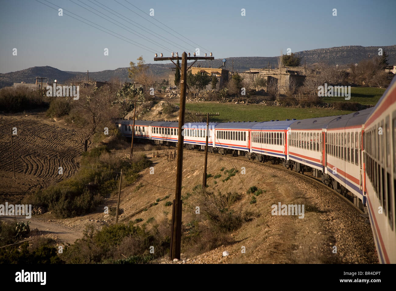Train en route through mountain village in Central Turkey. Stock Photo