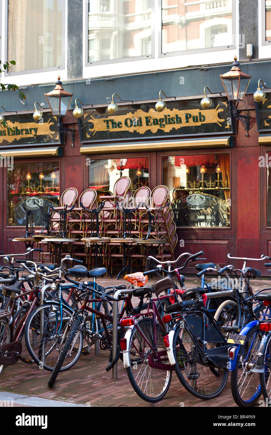 Bicycles parked outside English pub, Bakkers Straat, Amsterdam, Holland Stock Photo
