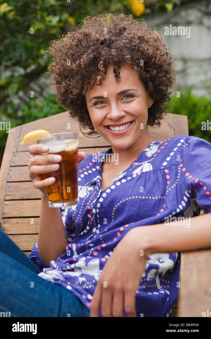 Mixed race woman drinking iced tea Stock Photo Alamy