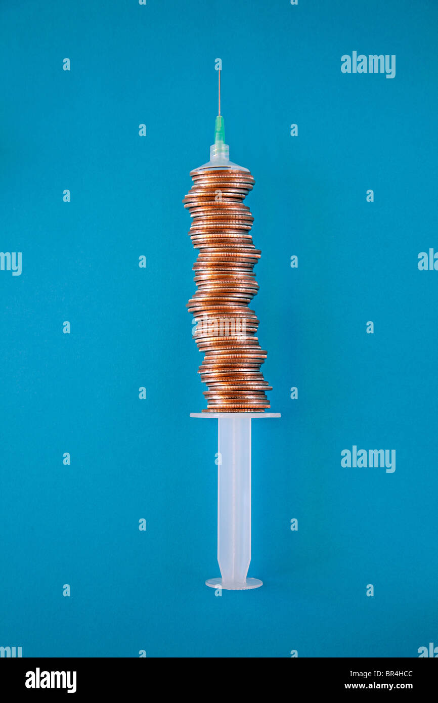stacked coins make medical syringe barrel Stock Photo