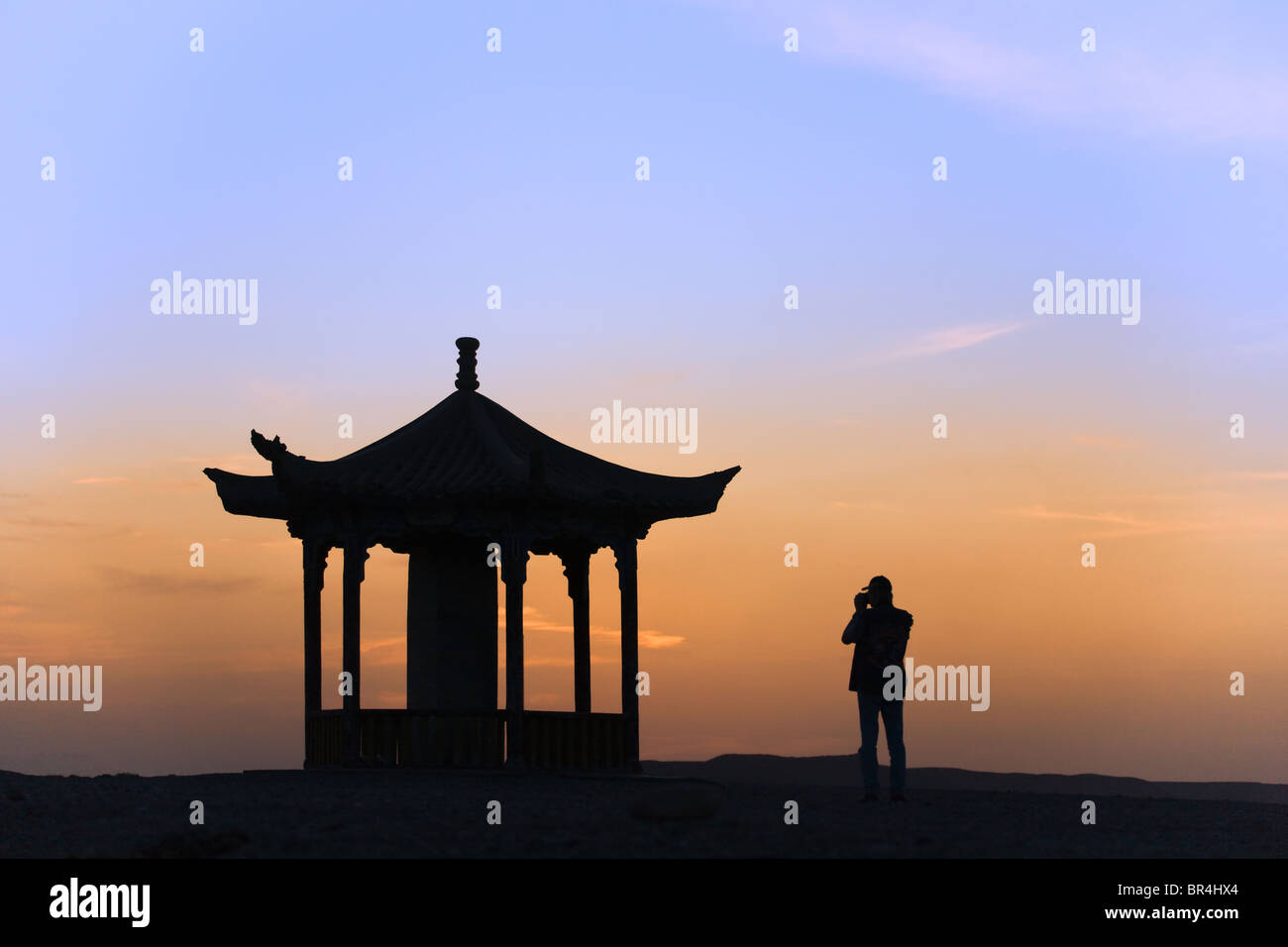 Western tourist with pavilion at sunset, Jiayuguan, Gansu Province, China Stock Photo