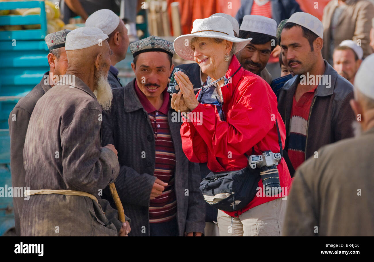 Tourists showing photos on camera to local Uighur people, Hotan, Xinjiang, China Stock Photo