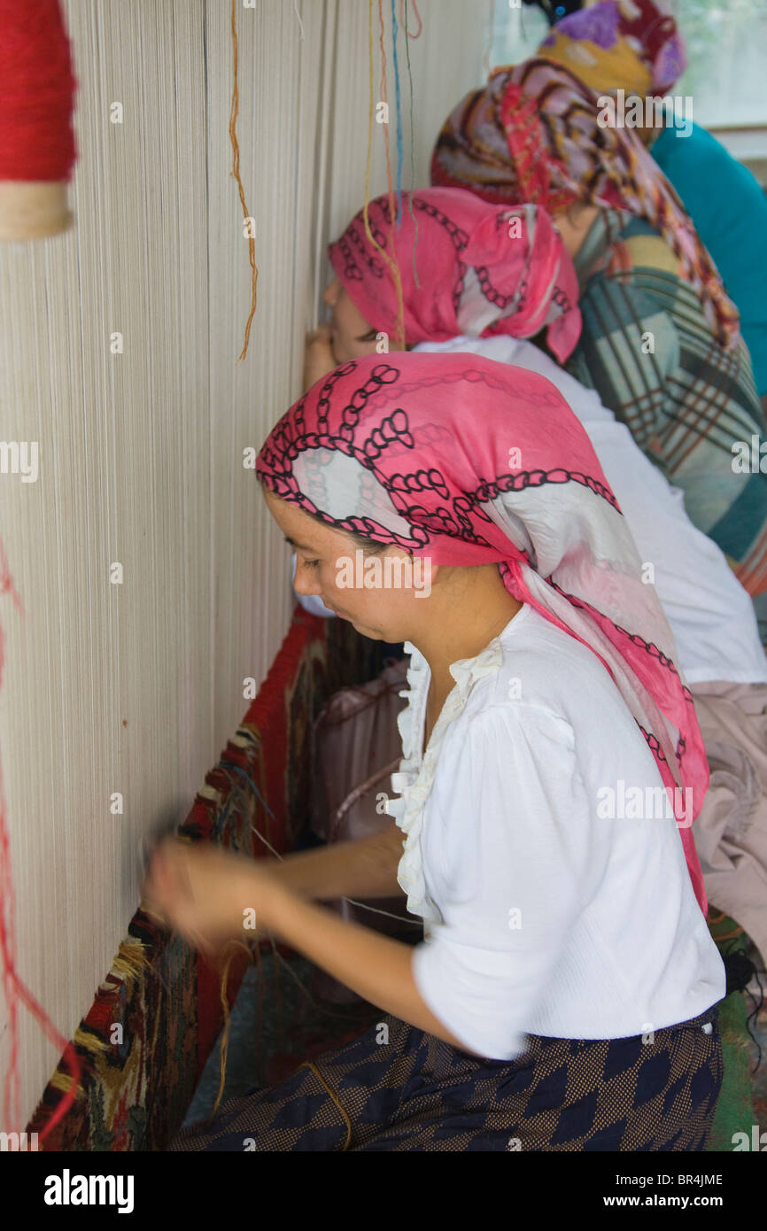 Uighur woman weaving carpet, Hotan, Xinjiang, China Stock Photo