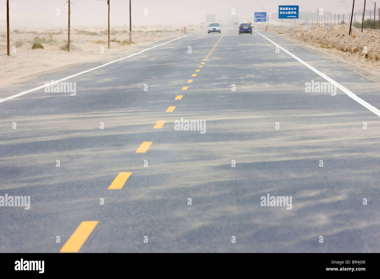 Storm blowing sand onto the road, Hotan, Xinjiang, China Stock Photo